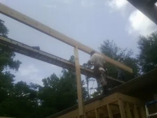 Carpenter setting a ridge beam over a new addition frame — Ice Dam Removal by Roofing Brothers in Pinesdale