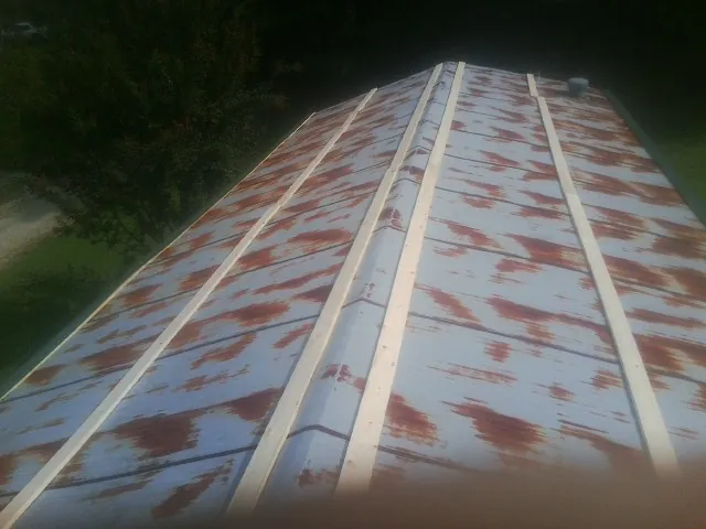 Rusted metal roof panels with new wood purlins before replacement — Storm Damage Roof Repair in Pinesdale by Roofing Brothers