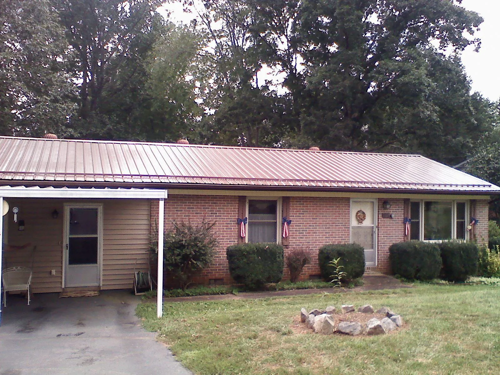Bronze metal roof and carport on a brick ranch home — Roof Repair work by our crew in Pinesdale